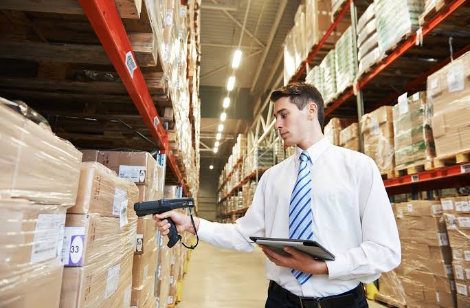 Warehouse worker scanning stock barcodes with a tablet in the distribution warehouse