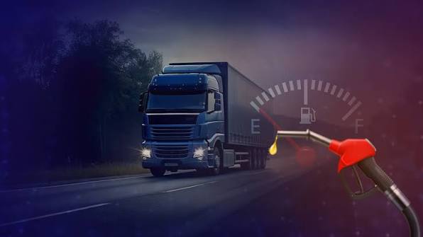 Truck on the highway at night with a fuel gauge and nozzle showing live fuel level